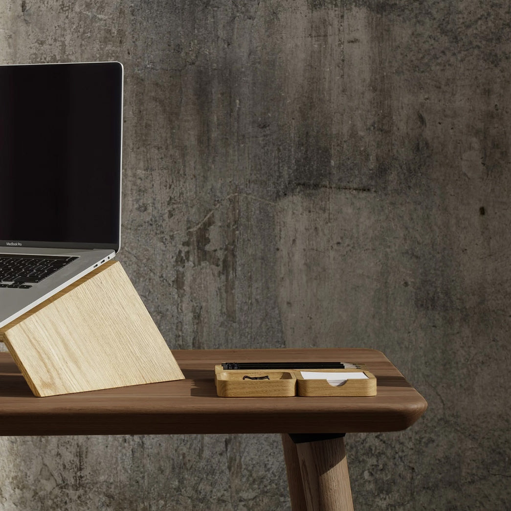 Light wood laptop stand and desk organizer on brown desk, minimalist workspace setup