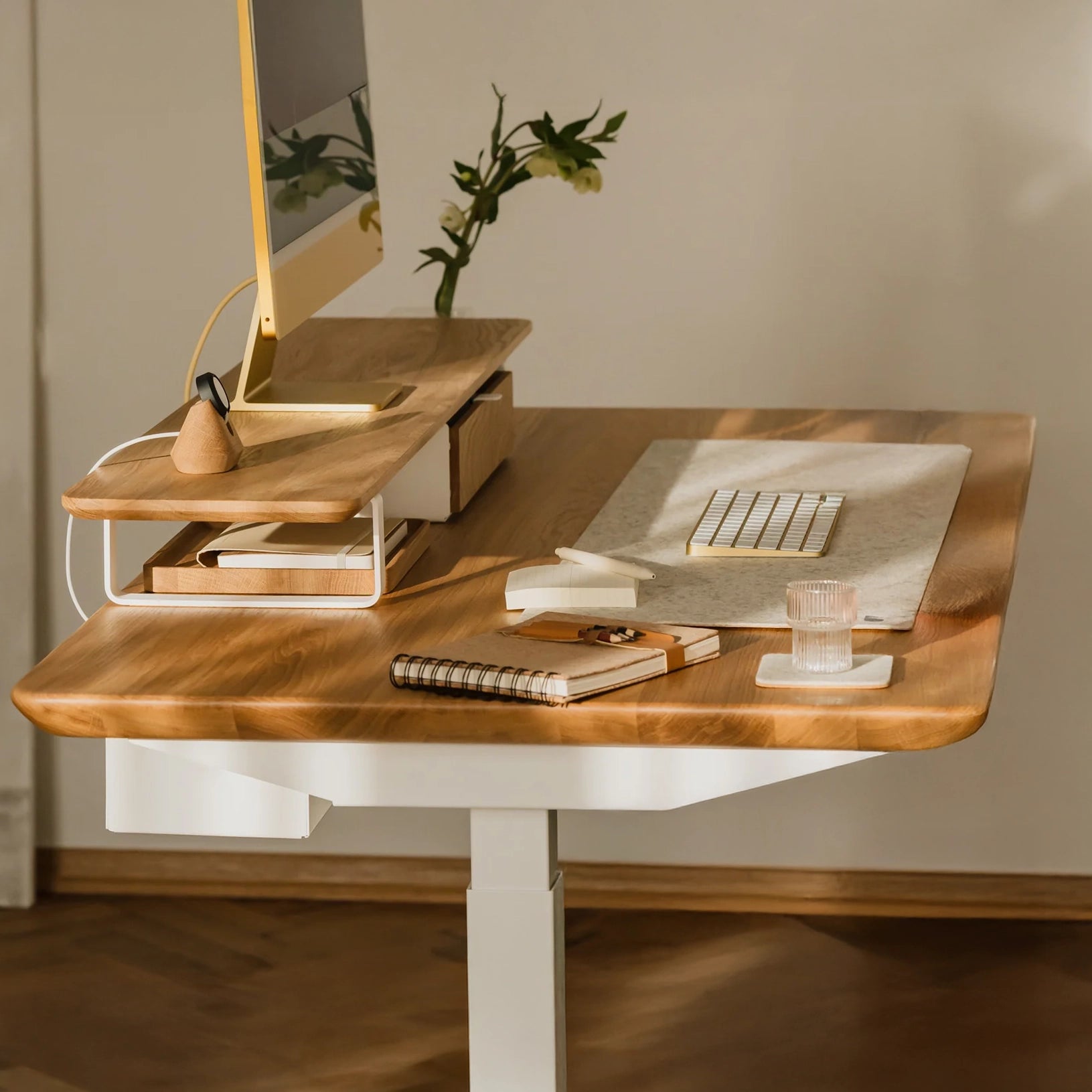 Pelicanwork standing desk with light wood top, computer monitor, and minimalist office setup
