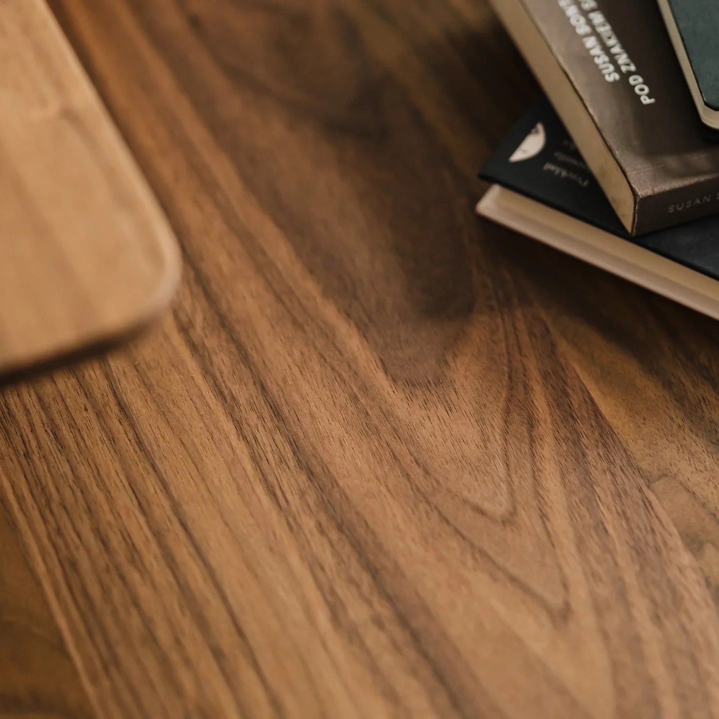 close-up of walnut Pelicanwork Standing Desk Pro desktop with books on top