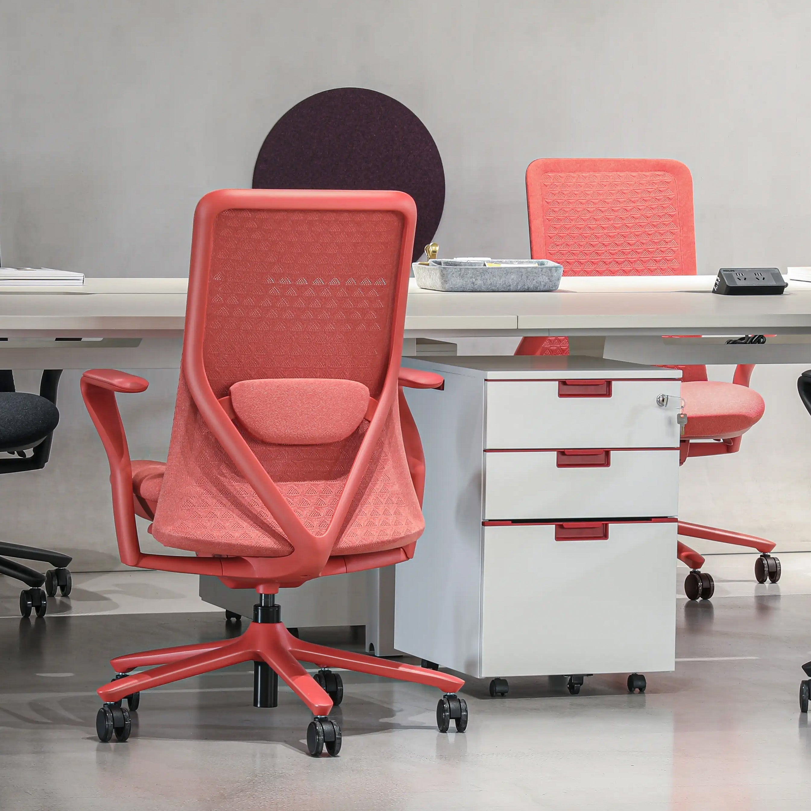 Pelicanwork Model 92 ergonomic office chair in coral pink with mesh back at modern desk