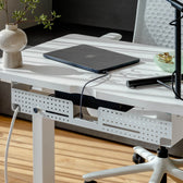White cable organizer mounted under height adjustable desk with modern office chair