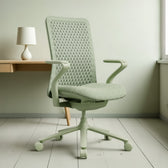 Green ergonomic office chair with mesh backrest and armrests in modern workspace